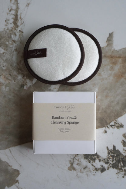 Touché Salli Bambura Gentle Cleansing Sponge, 2 stk. Hvide bambusfrotté svampe med mørkebrune kanter.