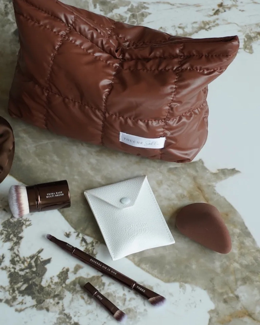 Touché Salli Ellipsa Soft Makeup Sponge i brun, ergonomisk formet til præcis påføring af makeup.
